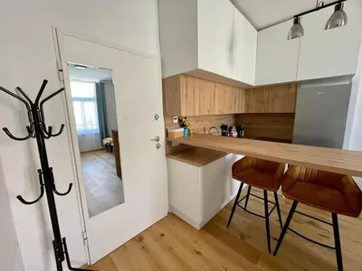 a kitchen with white cabinets and a wooden counter top at Mirno in elegantno stanovanje - Parkirišče, Netflix, wifi in Maribor