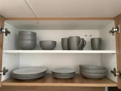 a shelf filled with bowls and plates and vases at Mirno in elegantno stanovanje - Parkirišče, Netflix, wifi in Maribor