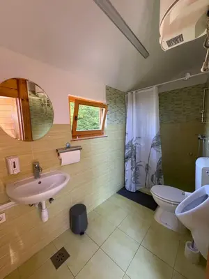 a bathroom with two sinks and a toilet and a window at Glamping Medvedjek - Nočitev v vinskem sodu in Velika Loka