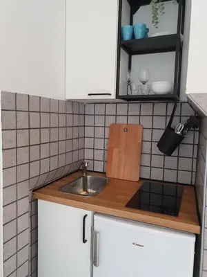 a kitchen with white cabinets and a sink at Sweet Vibes Studio at Šiška district, with Parking in Ljubljana