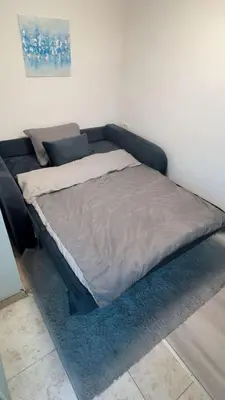 a bed sitting in a corner of a room at Cosy Corner Vič in Ljubljana