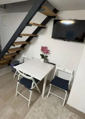 a white table and chairs in a room with stairs at Cosy Corner Vič in Ljubljana