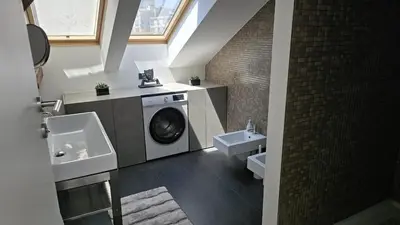 a bathroom with a washing machine and a sink at Funky Stylish Penthouse in Ljubljana
