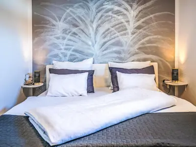 a bedroom with a large bed with two pillows at Apartment Adelsberg Inn-2 by Interhome in Postojna