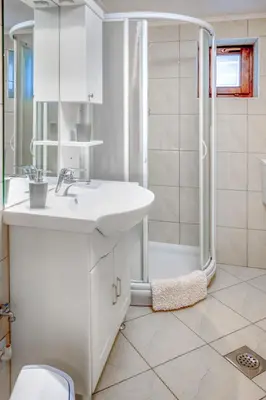 a white bathroom with a sink and a shower at Apartment Adelsberg Inn-2 by Interhome in Postojna