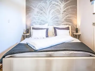 a bedroom with a large bed with a wall at Apartment Adelsberg Inn-2 by Interhome in Postojna