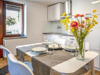a kitchen with a table with a vase of flowers on it at Apartment Adelsberg Inn-2 by Interhome in Postojna