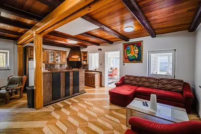 a living room with a red couch and a kitchen at 4 Bedroom Villa with Heated Indoor Pool Jajo & Pajo in Fala