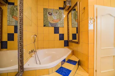 a bath tub in a bathroom with yellow tiles at 4 Bedroom Villa with Heated Indoor Pool Jajo & Pajo in Fala