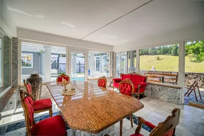 a dining room with a table and red chairs at 4 Bedroom Villa with Heated Indoor Pool Jajo & Pajo in Fala