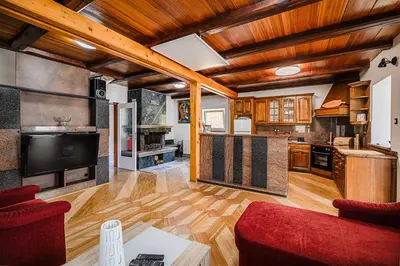 a large kitchen with wooden ceilings and a red couch at 4 Bedroom Villa with Heated Indoor Pool Jajo & Pajo in Fala