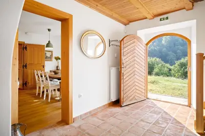 a door leading to a kitchen and dining room with a table at Old Castle Lodge in Kamnik