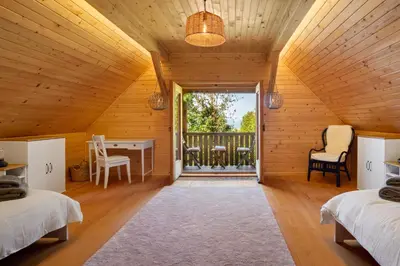 a bedroom with two beds and a table and a balcony at Old Castle Lodge in Kamnik
