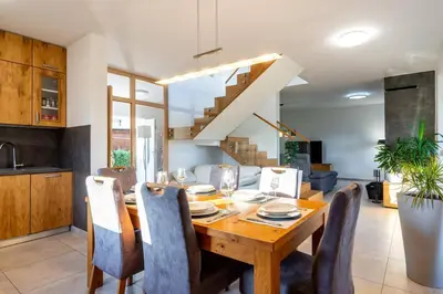 a kitchen and dining room with a wooden table and chairs at Villa Aqua in Moravske Toplice