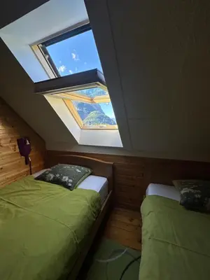 two beds in a room with a skylight at Apartment Pohar in Log pod Mangartom