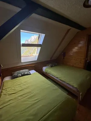 two beds in a room with a window at Apartment Pohar in Log pod Mangartom