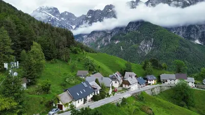 a village on a hill with a road in the mountains at Apartment Pohar in Log pod Mangartom