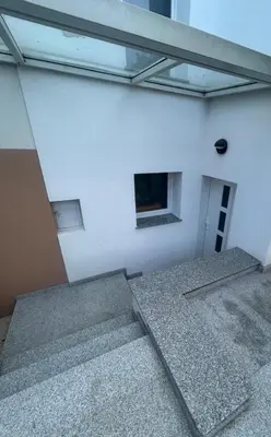 a white building with stairs and a window at Betnava Apartment in Maribor