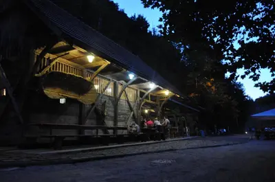 a group of people sitting outside of a building at night at Kamp Jankovic in Gorenjcj