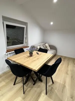 a wooden table in a living room with a couch at Mountain Escape with Sauna in Kobarid
