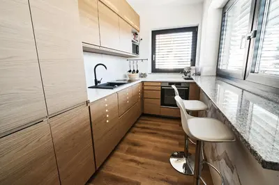 a kitchen with wooden cabinets and white counters at Alpine View Premium in Komenda