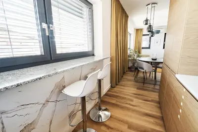 a hallway with two white chairs and a window at Alpine View Premium in Komenda