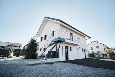 a white house with a staircase in a driveway at Alpine View Premium in Komenda