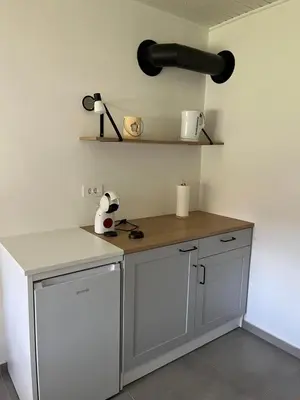 a kitchen with a counter with a light on the wall at Apartma Grahor in Selnica ob Dravi