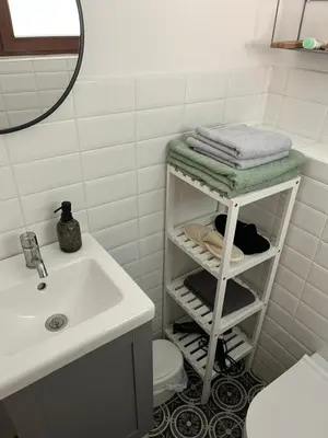 a bathroom with a sink and a shelf with towels at Apartma Grahor in Selnica ob Dravi