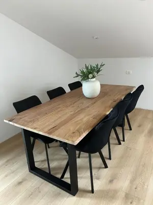 a wooden table with black chairs and a vase on it at Charming Alpine Apartment with Sauna in Kobarid