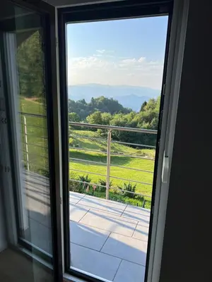 a sliding glass door with a view of a yard at Charming Alpine Apartment with Sauna in Kobarid