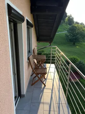a balcony with two rocking chairs on a house at Charming Alpine Apartment with Sauna in Kobarid