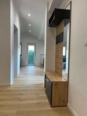 a hallway of a house with a mirror on the wall at Charming Alpine Apartment with Sauna in Kobarid