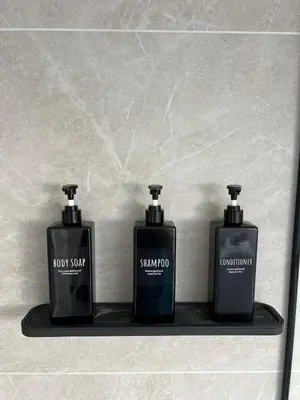 three bottles of soap sitting on a shelf at Charming Alpine Apartment with Sauna in Kobarid