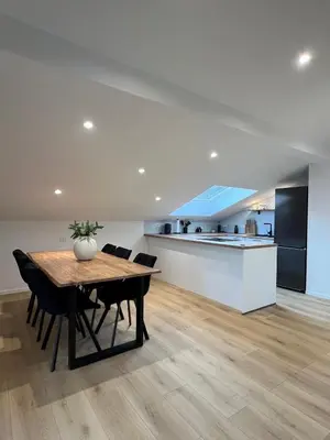 a dining room and kitchen with a table and chairs at Charming Alpine Apartment with Sauna in Kobarid