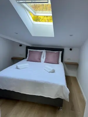 a bedroom with a large bed with a skylight at Charming Alpine Apartment with Sauna in Kobarid