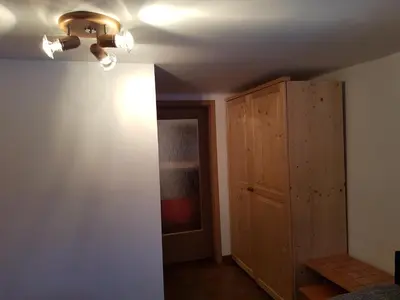 a room with a ceiling fan and a wooden cabinet at Penzion Pr' Betel in Jesenice