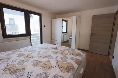a bedroom with a bed and a large window at M&M apartma in Bohinj