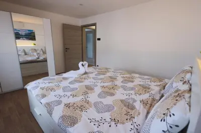 a bedroom with a bed with a swan on it at M&M apartma in Bohinj