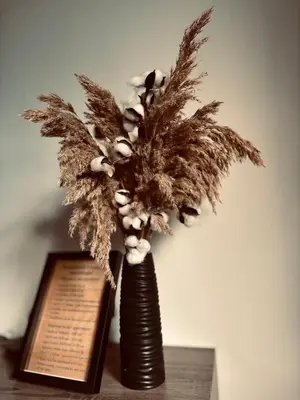 a vase filled with feathers sitting on top of a table at M&M apartma in Bohinj