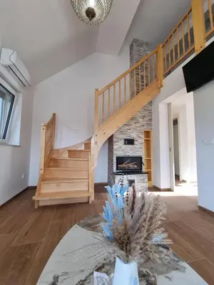 a living room with a staircase and a fireplace at Domačija Rajsko srce in Šentjur