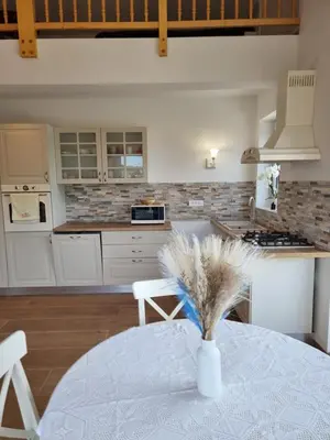 a kitchen with a table and a vase with feathers at Domačija Rajsko srce in Šentjur