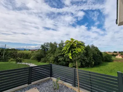 a fence with a tree on top of it at Domačija Rajsko srce in Šentjur