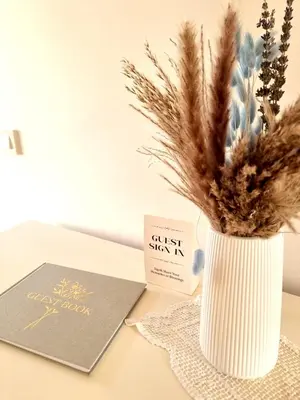 a book and a vase with some dried grass at Domačija Rajsko srce in Šentjur