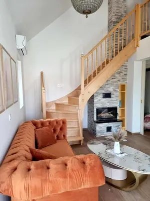 a living room with a couch and a staircase at Domačija Rajsko srce in Šentjur