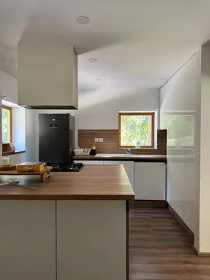 a kitchen with white cabinets and a wooden counter top at Cozy Mountain Stay near Kranjska Gora in Gozd Martuljek
