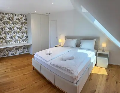 a bedroom with a large white bed in a attic at Crown Residence Luxury 2BR in Ljubljana Downtown in Ljubljana