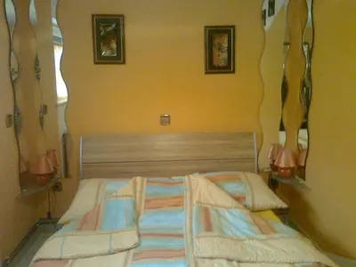 a bedroom with two beds and two lamps on the wall at Apartma 