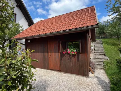 a wooden dog house with flowers in the window at Cvetlični Vrt in Radovljica
