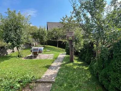 a garden with a wooden sign in the grass at Cvetlični Vrt in Radovljica
